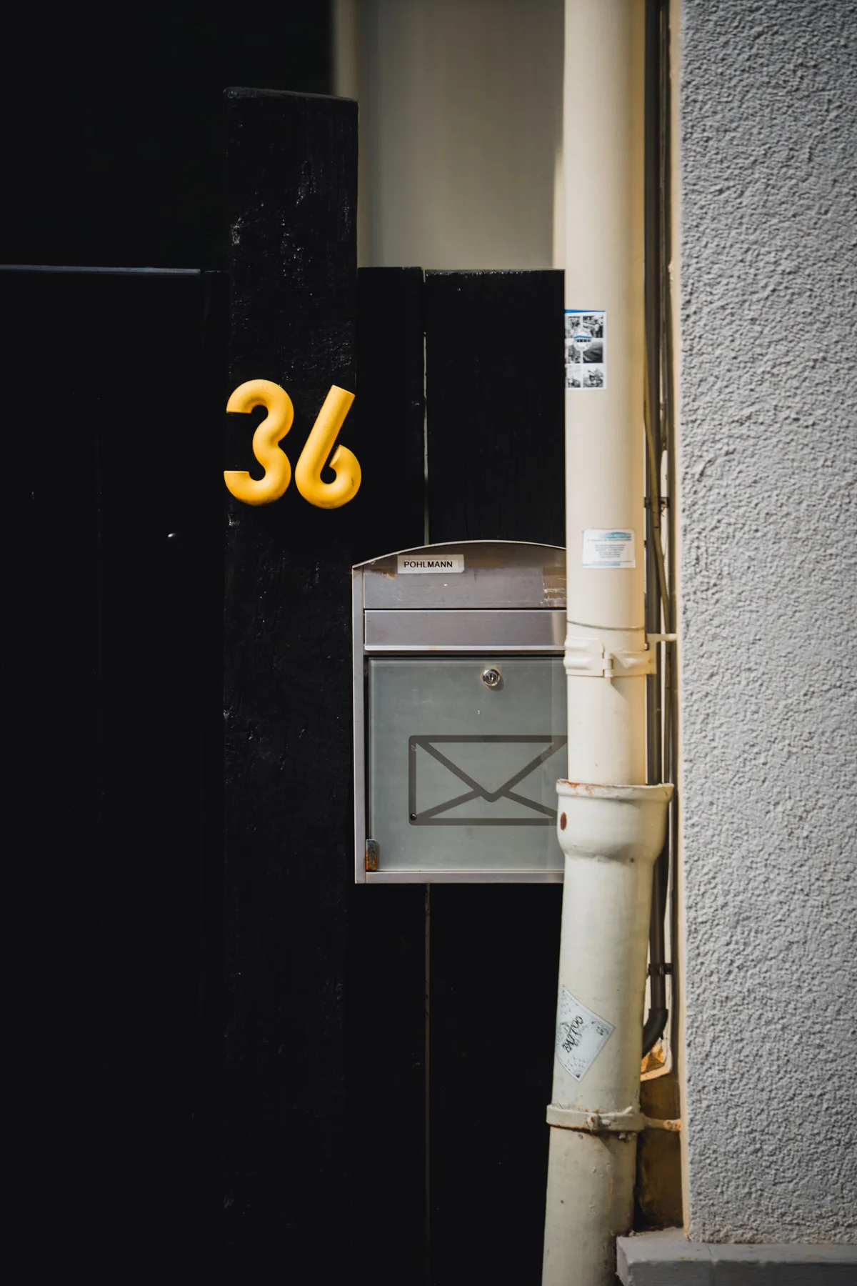 A house number "36" and a mailbox with a nameplate, both clearly legible beside a front door